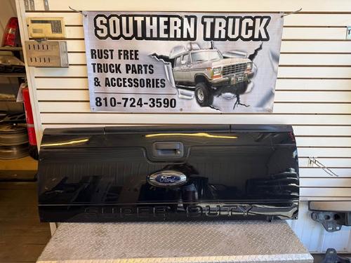 2013 2014 2015 2016 FORD SUPER DUTY TAILGATE WITH STEP. MISSING CAMERA BUT HAS CAMERA HOLE. RH LOWER CORNER HAS CREASE, INDENT ON LH UPPER ABOVE BODY LINE, SCATTERED SMALL DINGS. RUST FREE. #16017